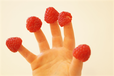 eine Hand, die eine Frucht hält